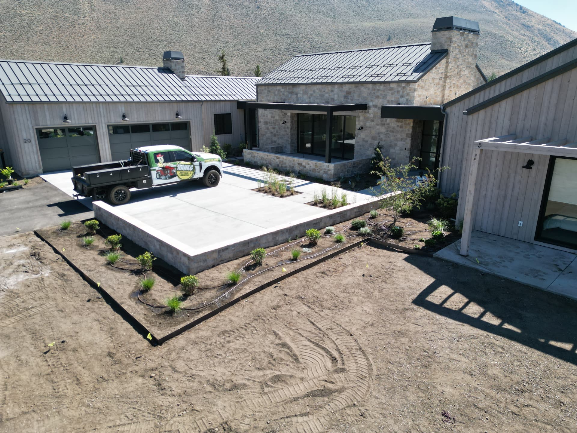 Hanks truck and crew prepping garden beds and irrigation lines at a modern home