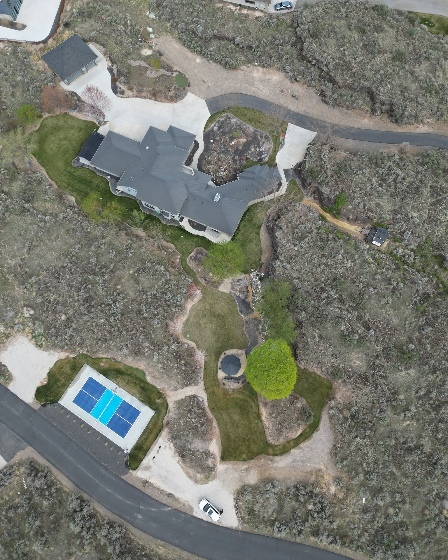 Aerial view of a custom home with landscaped yard and pool