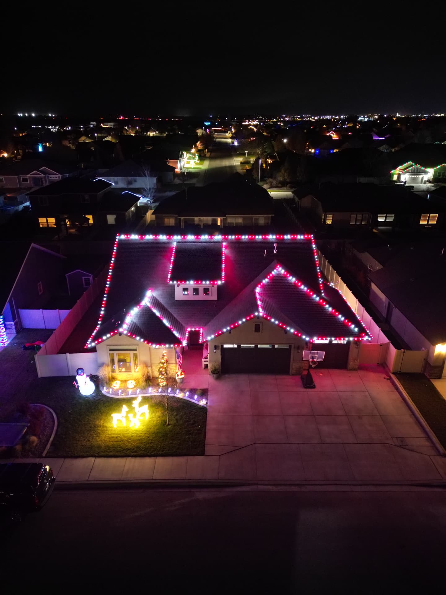 Aerial view of a home wrapped in red and white holiday lights