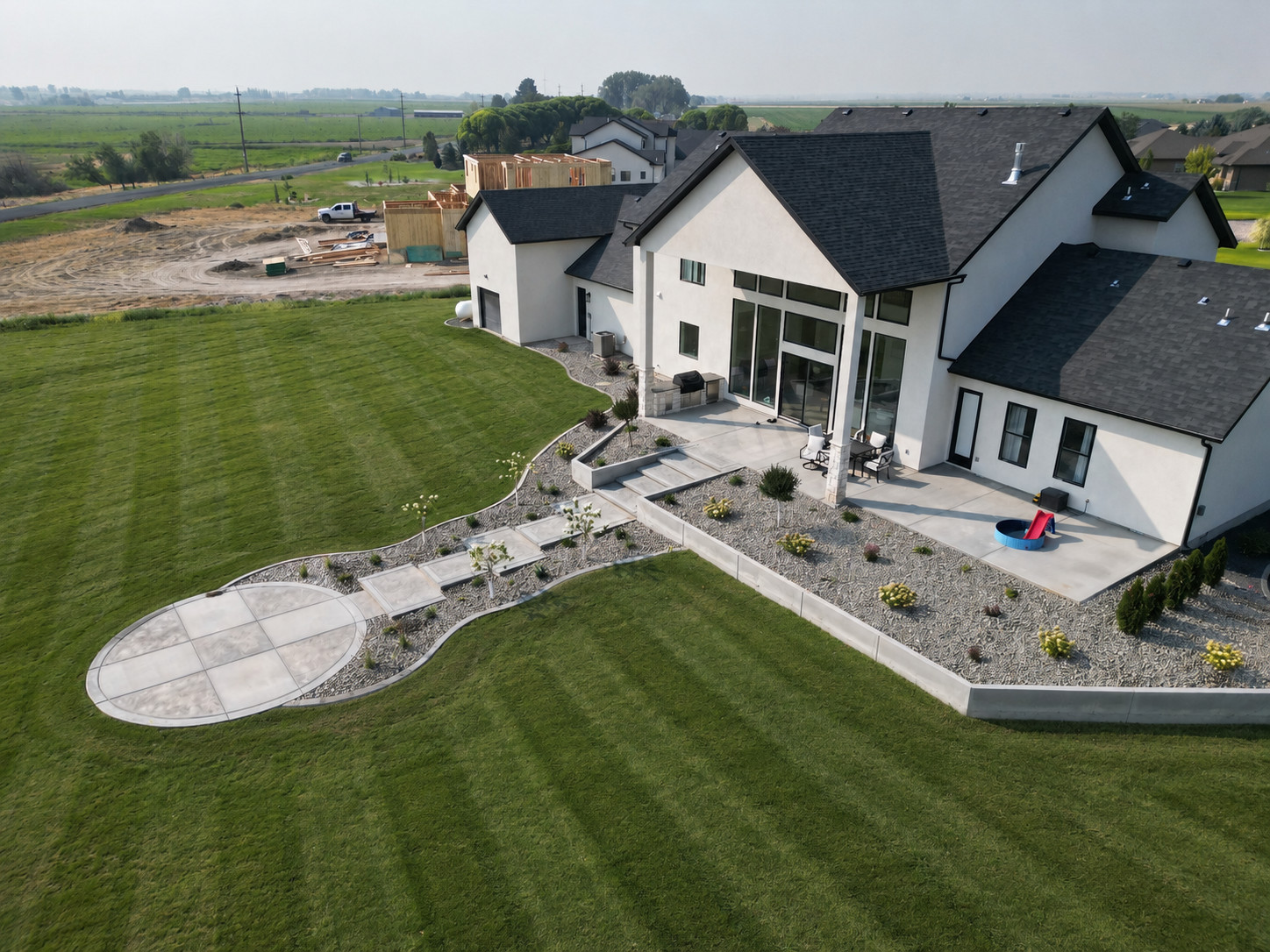 Aerial view of a modern home with lush green lawn and landscaped beds