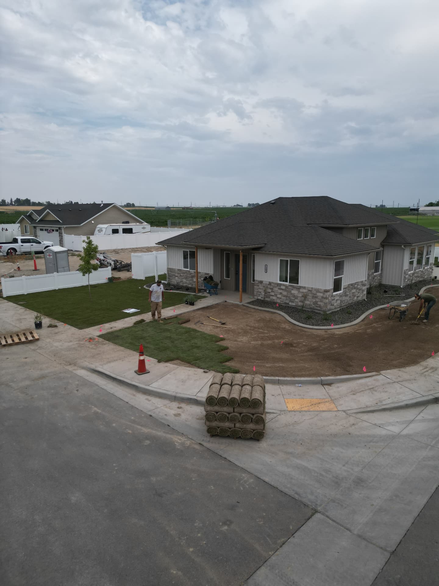 Two Hanks crew members laying fresh sod rolls in a front yard