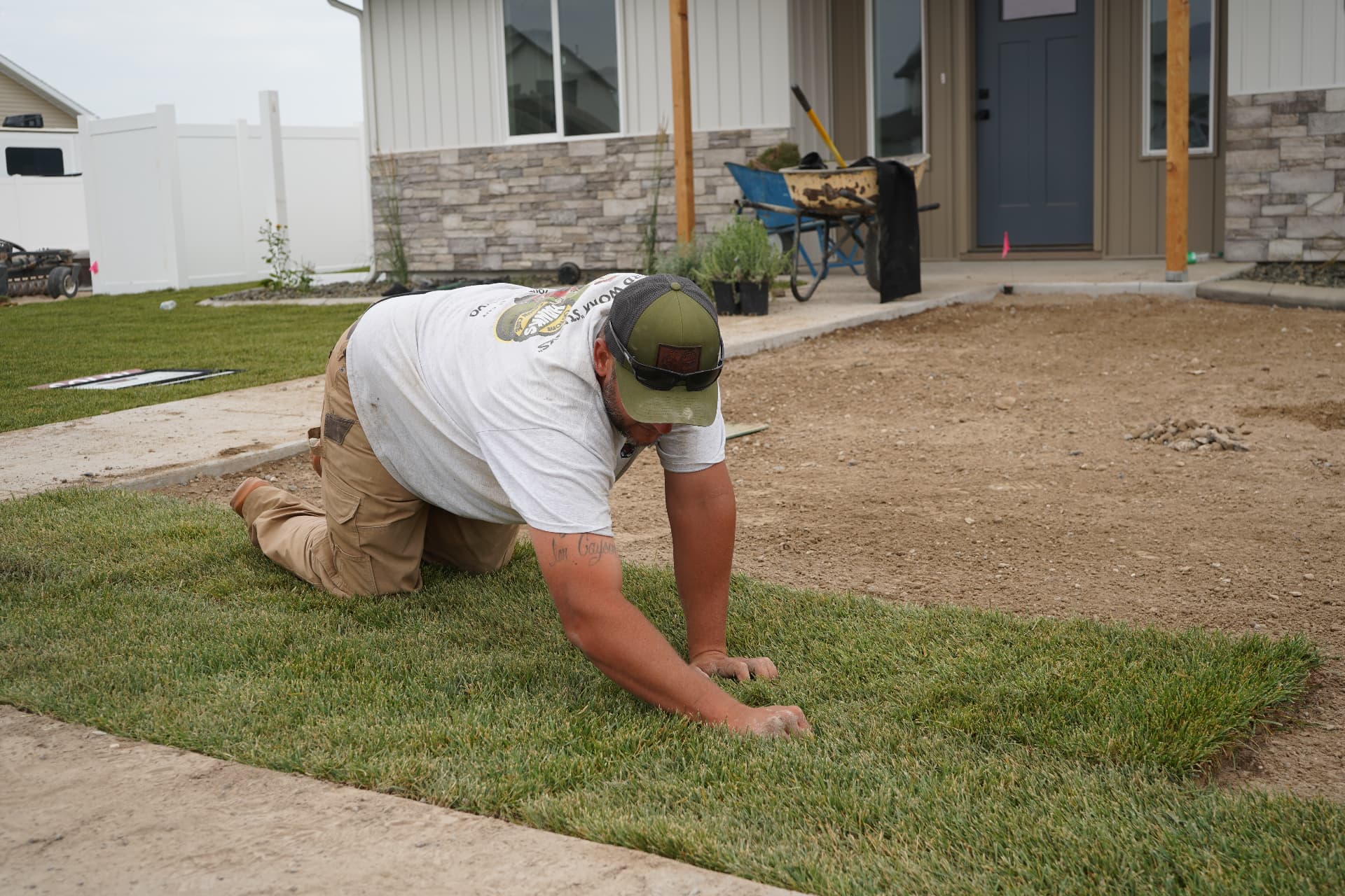 Hanks crew member carefully laying fresh sod by hand