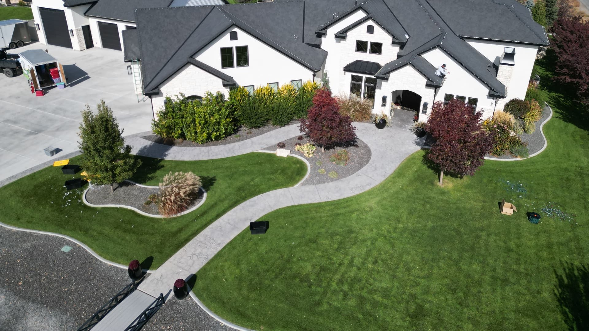 Aerial view of a beautifully landscaped home with healthy green lawn and curved walkways