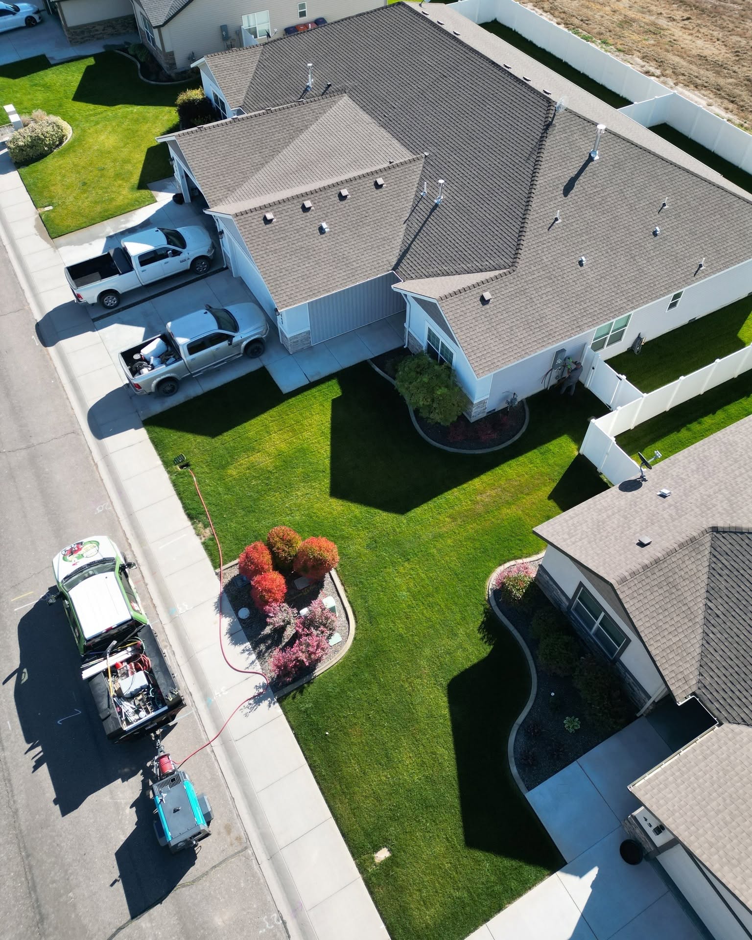 Aerial view of a Hanks crew servicing a lush green lawn and landscaped beds