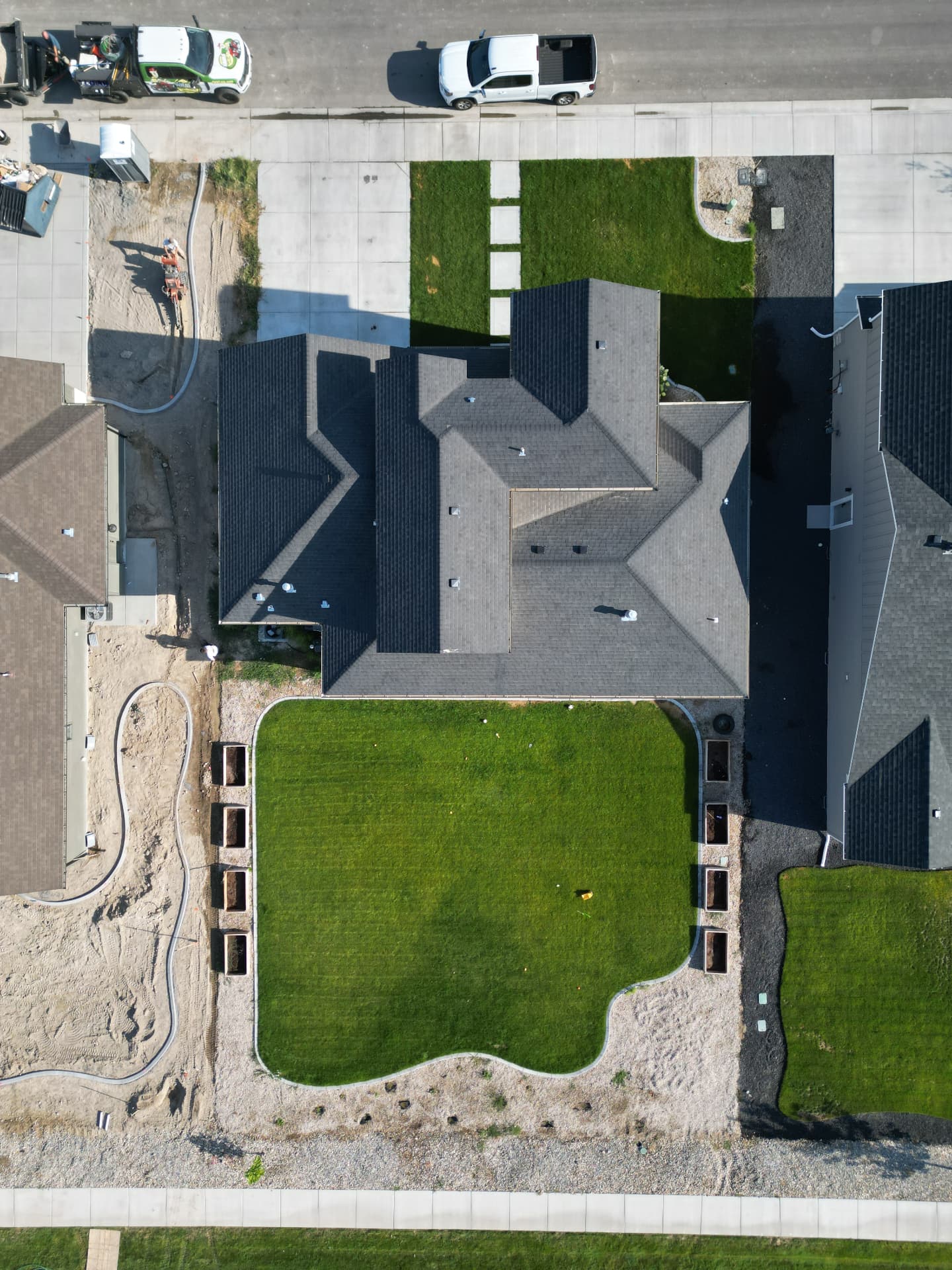 Aerial view of a large home with manicured lawn, gravel borders and planter boxes