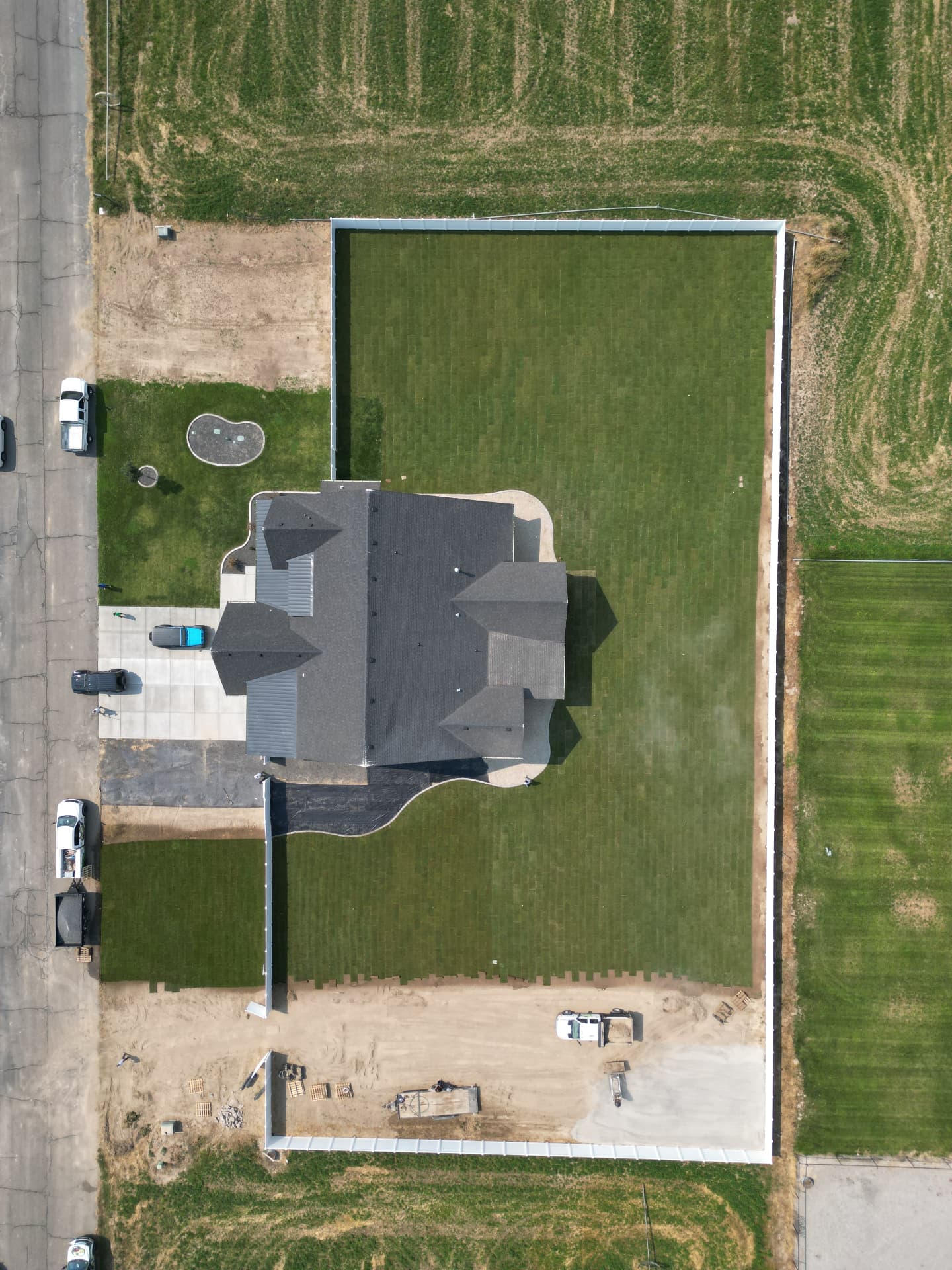 Aerial view of a newly sodded backyard with white fence and the Hanks truck on site